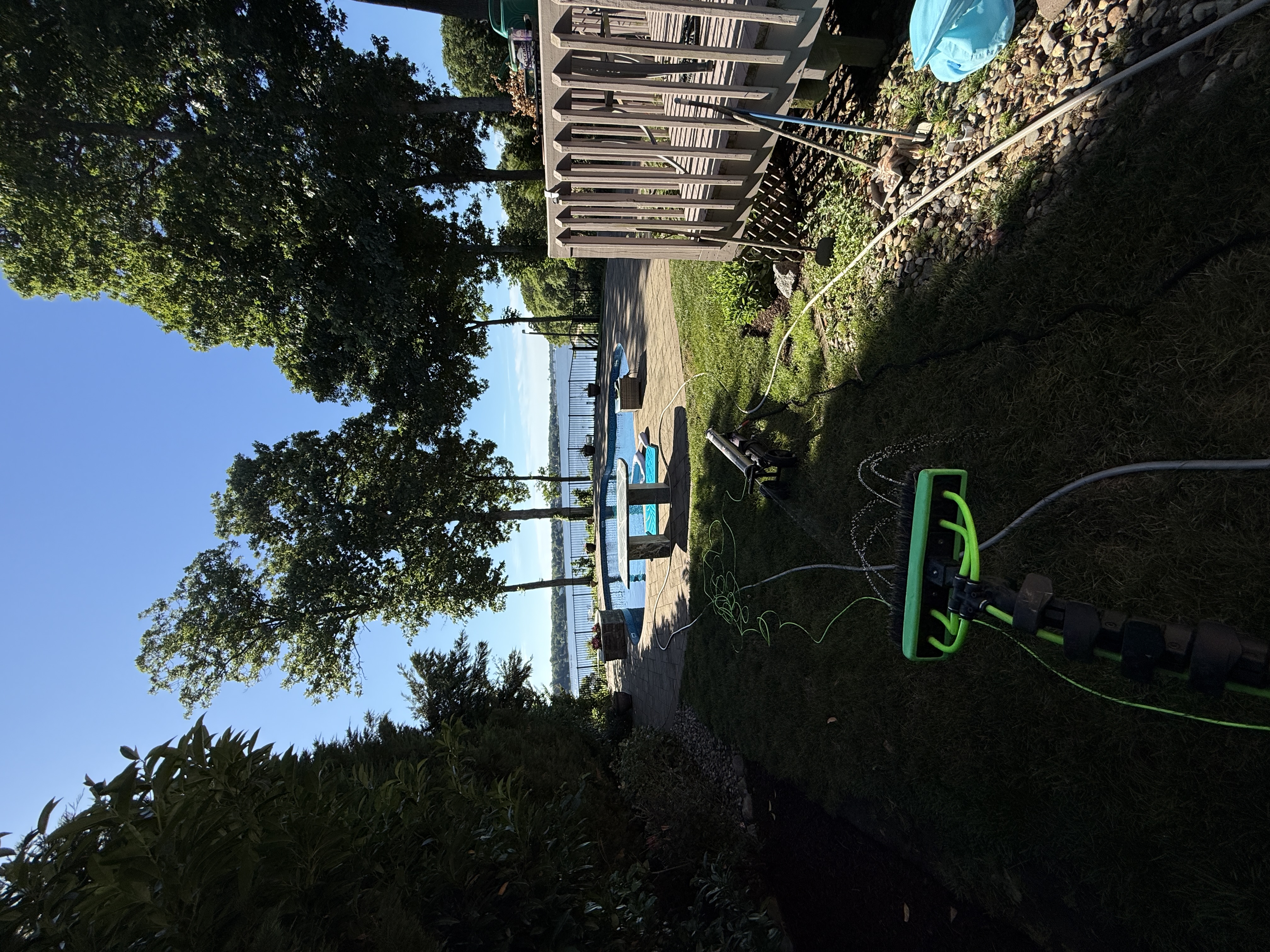Exterior cleaning setup near a pool and deck